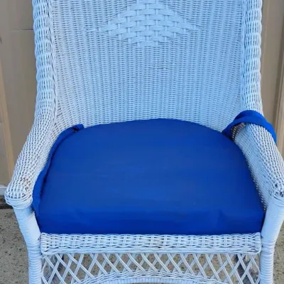 White Wicker-Style Armchair with Blue Cushion