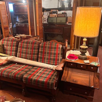 Sale Photo Thumbnail #43: Vintage plaid upholstered wooden sofa alongside a coordinating wooden side table with an ornate brass table lamp.