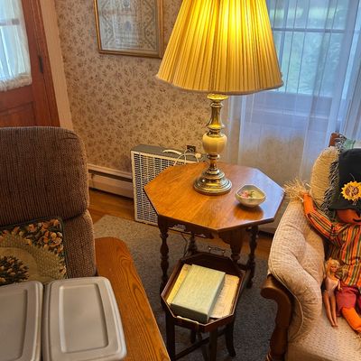 Sale Photo Thumbnail #134: Vintage brass and ceramic table lamp with a pleated fabric shade, accompanied by an octagonal wooden side table.