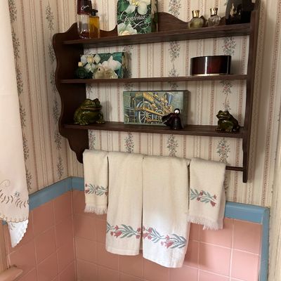 Sale Photo Thumbnail #100: Vintage dark wood wall-mounted display unit featuring three shelves, a bottom towel rack bar, and scalloped side details.