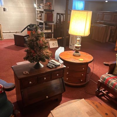 Sale Photo Thumbnail #52: Vintage wooden side tables, a tall table lamp with a textured shade, a small decorative Christmas tree, and assorted rustic living room furniture.