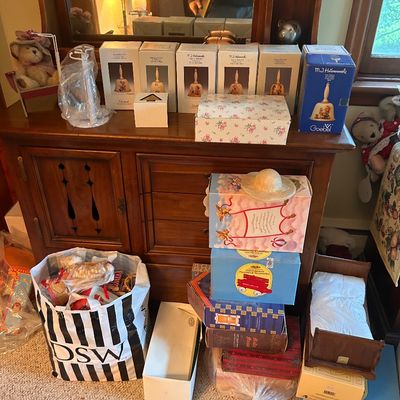 Sale Photo Thumbnail #97: A wooden cabinet and mirror surrounded by collectible M.I. Hummel bell boxes, doll furniture, and various collectibles.