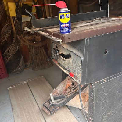 Sale Photo Thumbnail #22: Vintage stationary table saw with a rip fence, miter gauge, and a can of WD-40.