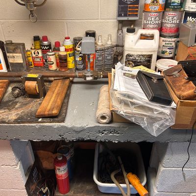 Sale Photo Thumbnail #53: Workshop workbench filled with assorted tools, paint cans, hardware supplies, and leather cases.