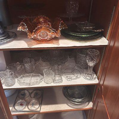 Sale Photo Thumbnail #144: Collection of vintage pressed and cut glassware, featuring a marigold carnival glass ruffled bowl, clear glass serving pieces, and bird-motif glass coasters.