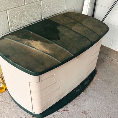 Sale Photo Thumbnail #141: Rubbermaid outdoor plastic deck storage box with a dark green hinged lid and beige body.