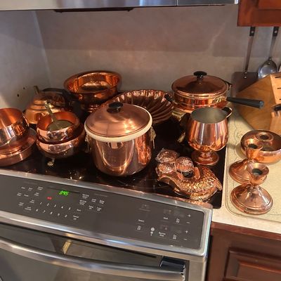 Sale Photo Thumbnail #7: Collection of polished copper cookware and decorative items, including pots, bowls, candle holders, and a fish mold.