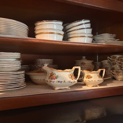 Sale Photo Thumbnail #140: Vintage fine porcelain dishware set featuring floral motif gravy boats, teacups, saucers, and plates.