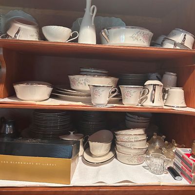 Sale Photo Thumbnail #25: Collection of porcelain china dining pieces with delicate floral motifs and silver-toned rims, alongside serving dishes, glassware, and teacups.
