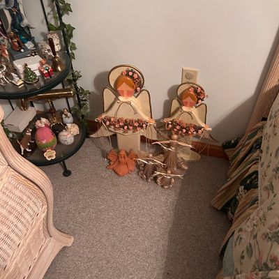 Sale Photo Thumbnail #118: Collection of decorative angel figurines, including painted wooden standing angels adorned with faux floral garlands and straw angel accents.