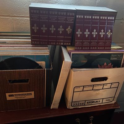Sale Photo Thumbnail #73: Collection of vintage vinyl LP record albums housed in storage boxes alongside two boxed sets of Encyclopedia of Music volumes.