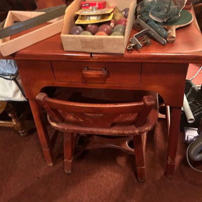 Sale Photo Thumbnail #65: Vintage wooden desk and chair set with game accessories, including bocce balls and table tennis equipment.
