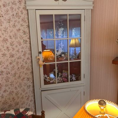 Sale Photo Thumbnail #126: White painted traditional corner hutch featuring glass paneled upper cabinet doors and decorative pediment top.