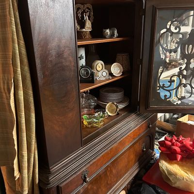 Sale Photo Thumbnail #49: Vintage wood hutch cabinet filled with small collectibles, tableware, and clocks.