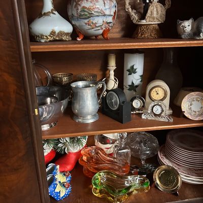 Sale Photo Thumbnail #37: Collection of vintage decorative items including porcelain vases, a hand-painted ginger jar, small desk clocks, metal tankards, crystal glass, and colorful art glass dishes.