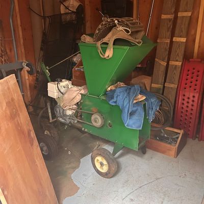Sale Photo Thumbnail #2: Gas-powered green wood chipper shredder with a large hopper and wheeled frame.