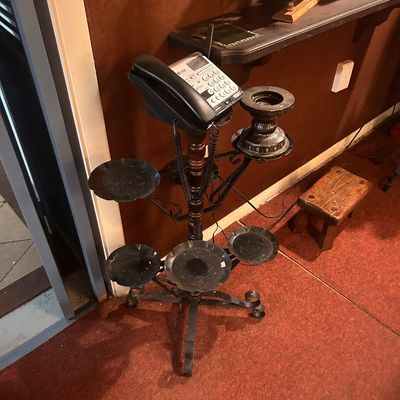 Sale Photo Thumbnail #70: Vintage multi-tiered wrought iron and turned wood plant stand alongside an AT&T corded landline telephone.