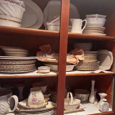 Sale Photo Thumbnail #145: Large collection of fine porcelain tableware and china, including floral tea pieces, dinner plates, bowls, serving platters, and small decorative vases with gold trim accents.
