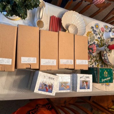 Sale Photo Thumbnail #138: Collection of boxed Christmas decorations and figurines alongside table linens and ceramic decor.
