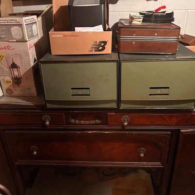 Sale Photo Thumbnail #68: Vintage dark wood sideboard cabinet with decorative brass pulls, featuring olive green metal storage drawers and boxed items.