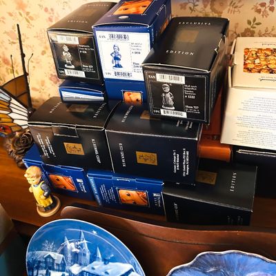 Sale Photo Thumbnail #112: Collection of M.I. Hummel figurines in original boxes, accompanied by a small Hummel figurine and decorative collector plates.