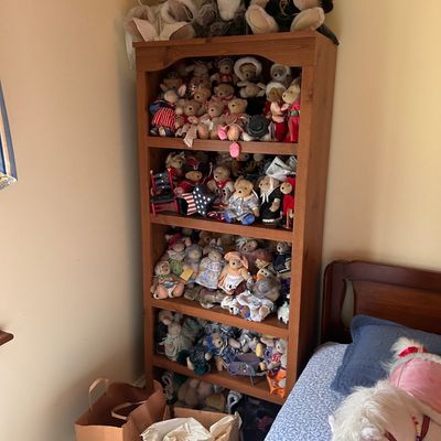 Sale Photo Thumbnail #103: A wooden bookcase filled with a large collection of assorted stuffed teddy bears and plush animals.