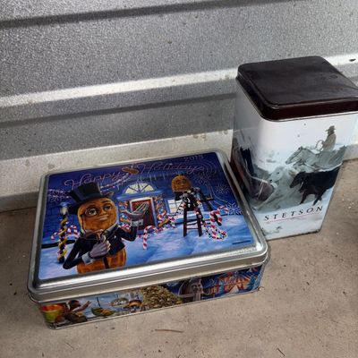 Sale Photo Thumbnail #81: A pair of decorative collectible metal tins. Includes one 2013 Mr. Peanut 'Happy Holidays' rectangular tin featuring Planters character artwork and one tall Stetson tin featuring Western horse imagery. Both tins show light surface wear consistent with age