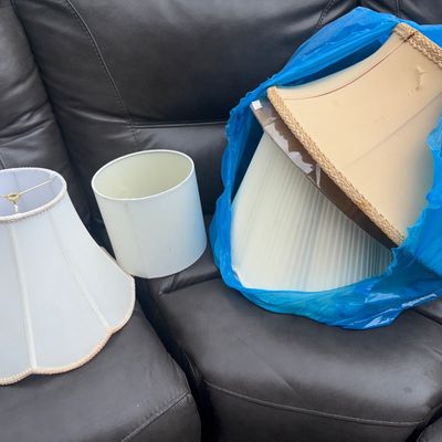 Sale Photo Thumbnail #79: 6 shades. Collection of four assorted lamp shades in various shapes and styles. Includes a white scalloped fabric shade with trim, a simple white drum shade, a large pleated beige shade, and a square cream-colored shade with braided trim. Shades show some