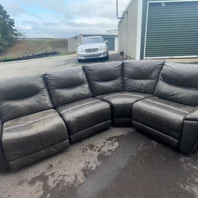 Sale Photo Thumbnail #51: A multi-piece dark grey/charcoal leather curved sectional sofa with plush, cushioned backrest and armrests. Features modular seating sections including a corner wedge. Shows signs of surface wear, scuffs, and creasing from use.
72in one one
101 in on the 