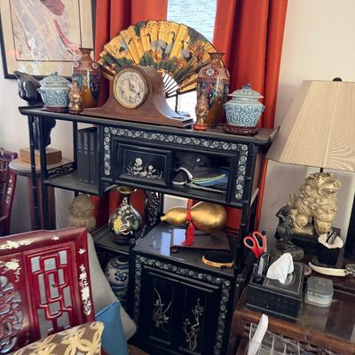 Sale Photo Thumbnail #10: Black lacquer shelf unit featuring mother-of-pearl inlay, holding a wooden mantel clock, folding decorative fan, cloisonné vases, and blue-and-white ginger jars.