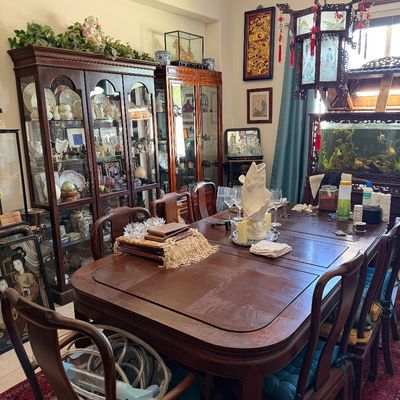 Sale Photo Thumbnail #25: Traditional Asian-style dining room set featuring a dark wood dining table with chairs, paired with matching glass-door display cabinets, an ornate pendant light, and decorative art.
