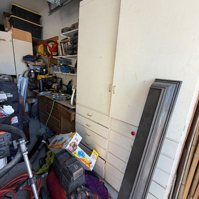 Sale Photo Thumbnail #30: Large white wooden storage cabinet unit with upper doors and multiple lower drawers in a garage setting.