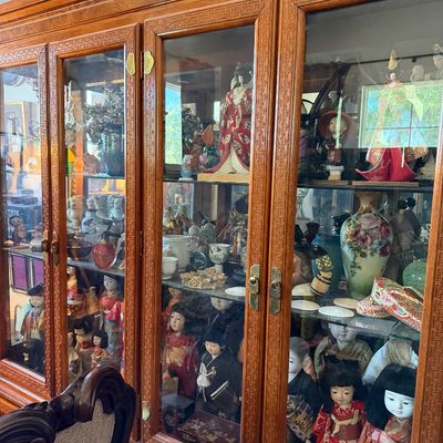 Sale Photo Thumbnail #16: Large wooden display cabinet filled with a collection of traditional Japanese dolls, porcelain, and Asian decorative collectibles.