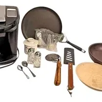 Assortment of kitchenware, including a Keurig single-serve coffee maker, frying pan, spatulas, salt and pepper shakers, and serving dishes.