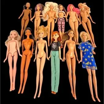 Collection of 12 fashion dolls, including Barbie and Disney characters, mostly unclad and in played-with condition.