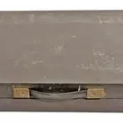 Vintage flat wooden storage case featuring metal latches, a carrying handle, and visible surface scuffs and markings.