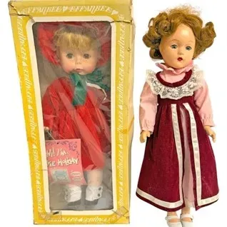Pair of vintage dolls, including a boxed Effanbee 'Pixie Holiday' doll and an unboxed doll in a red velvet and pink lace dress.