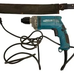 Vintage Makita corded power drill alongside a large machete with a dark canvas sheath.