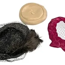Trio of vintage mid-century women's hats, including a black feathered pillbox with birdcage veiling, a beige satin hat, and a...