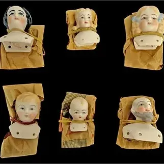 Collection of six antique porcelain and bisque doll shoulder heads, featuring hand-painted details including a bearded man and various...