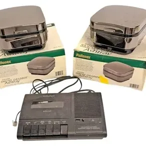 Pair of Pollenex Deluxe Smoke Grabber ashtrays with original boxes, alongside a black Radio Shack telephone cassette recorder, circa 1980s.