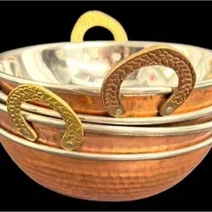 Stack of three traditional copper kadai serving bowls with brass handles and stainless steel lining.