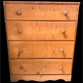 Antique rustic pine four-drawer dresser featuring round wooden knobs and a shaped apron base.
