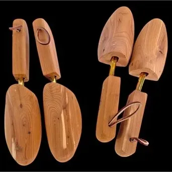 Two pairs of vintage natural cedar wood shoe trees with brass spring-loaded tension rods and leather heel loops.