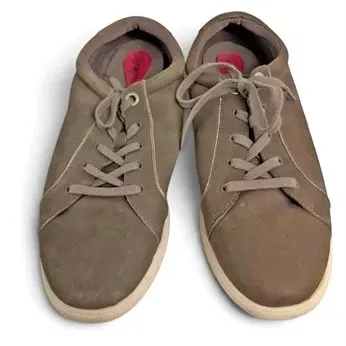 Pair of men's taupe suede lace-up sneakers featuring white soles and pink interior accents, in gently worn condition.