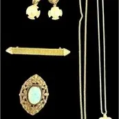 Collection of vintage gold-tone jewelry, including chain pendant necklaces, clip-on earrings, a bar brooch, and a faux turquoise ornate pin.