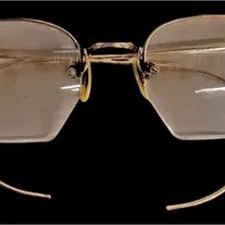 Vintage rimless eyeglasses featuring gold-tone cable temples and an engraved bridge, circa early-to-mid 20th century.