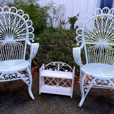 Two white wicker chairs and a wicker shelf