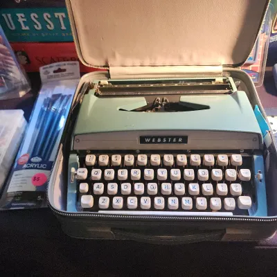 Sale Photo Thumbnail #105: Vintage Webster portable manual typewriter in a seafoam green and blue casing, complete with its original zippered carrying case.
