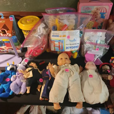 Collection of vintage toys and dolls, including plastic marble race components in bags, plush figures, baby dolls, and a boxed Barbie set.